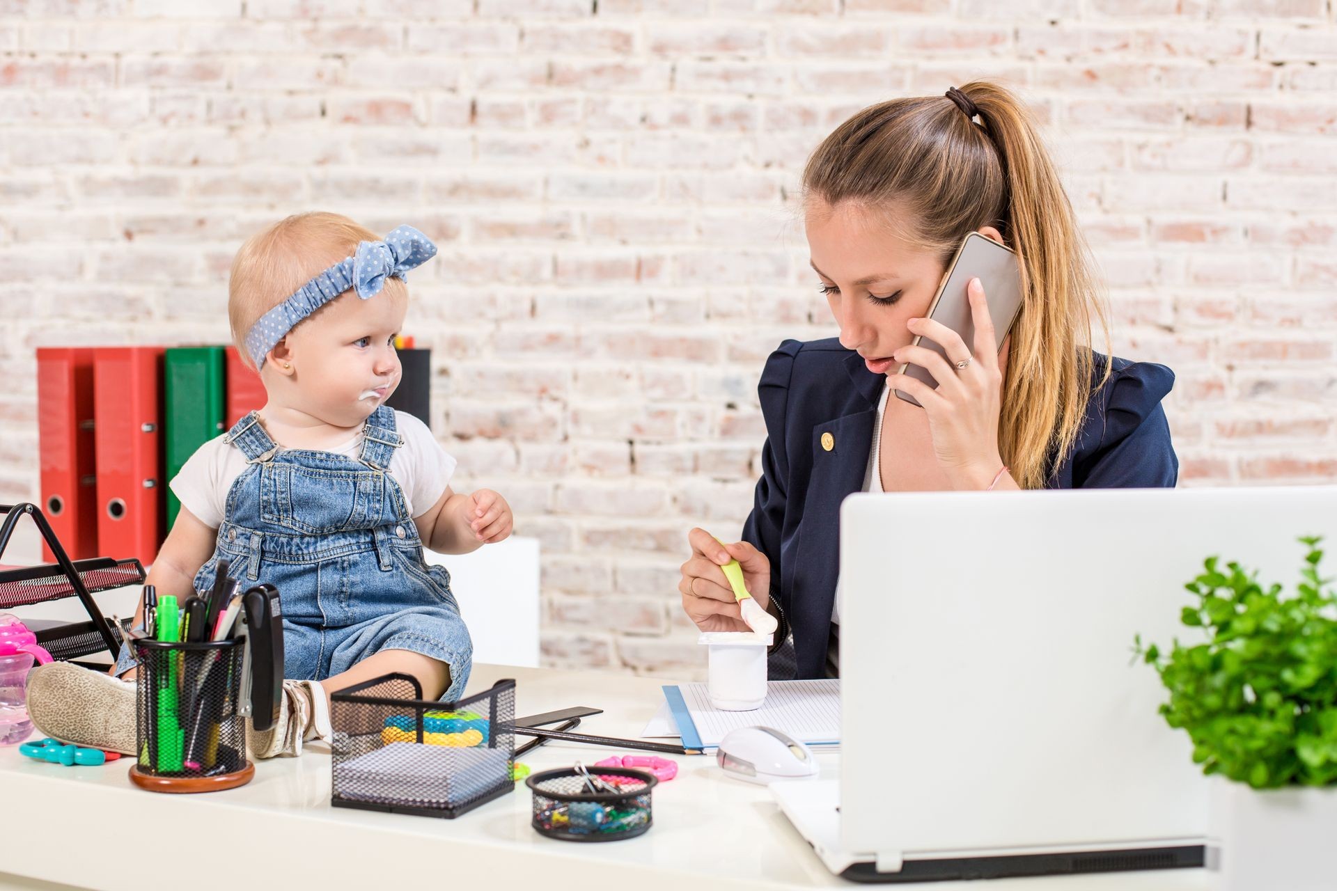 Family Business - telecommute Businesswoman and mother with kid is making a phone call